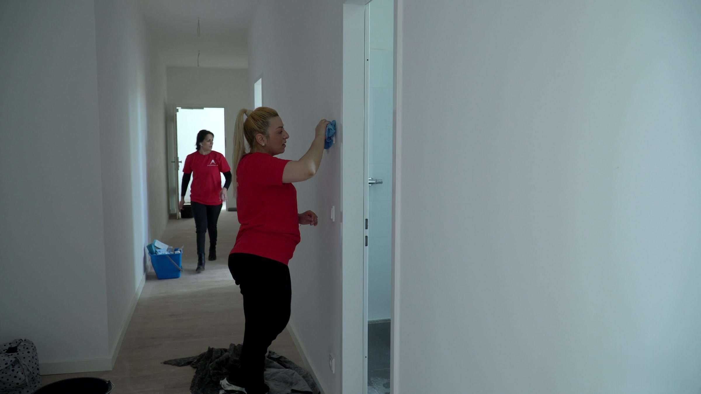 Gebäudereinigung Berlin: Zwei Reinigungskräfte der AMT multiservices im Flur einer Neubauwohnung